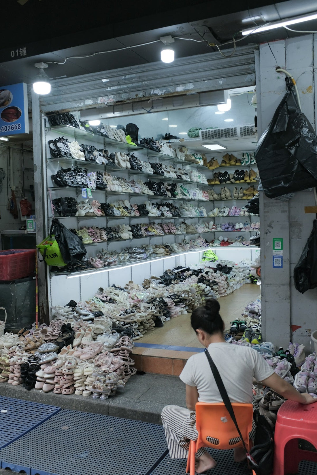 Shoe store with many sandals and sneakers displayed.